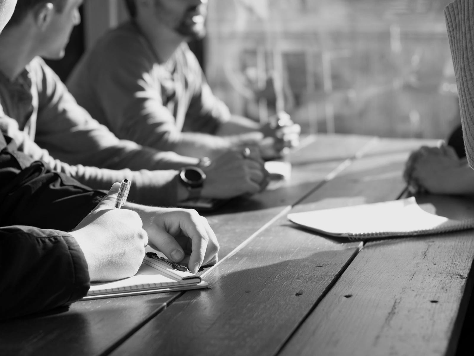 Equipe reunida em torno de uma mesa de trabalho